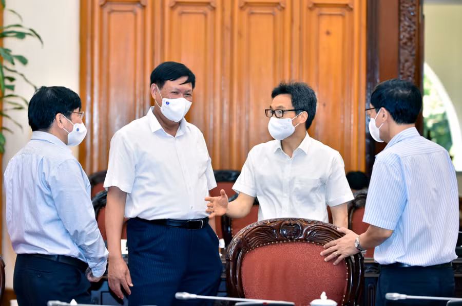Phó Thủ tướng Vũ Đức Đam trao đổi với lãnh đạo Bộ Y tế về tình hình dịch bệnh. - Ảnh: VGP/Nhật Bắc