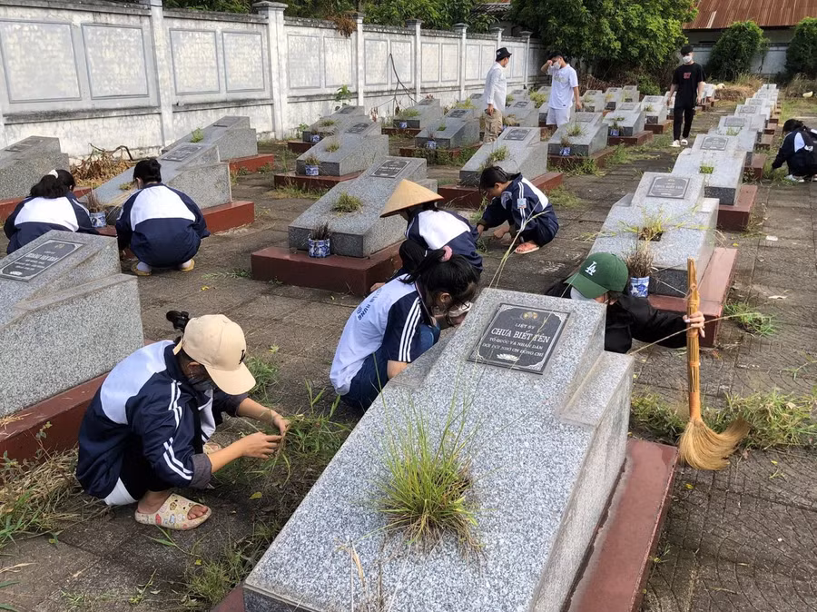 Học sinh Trường THPT Đức Hợp, Hưng Yên dọn dẹp và chăm sóc nghĩa trang liệt sĩ tại địa phương. Ảnh: NTCC
