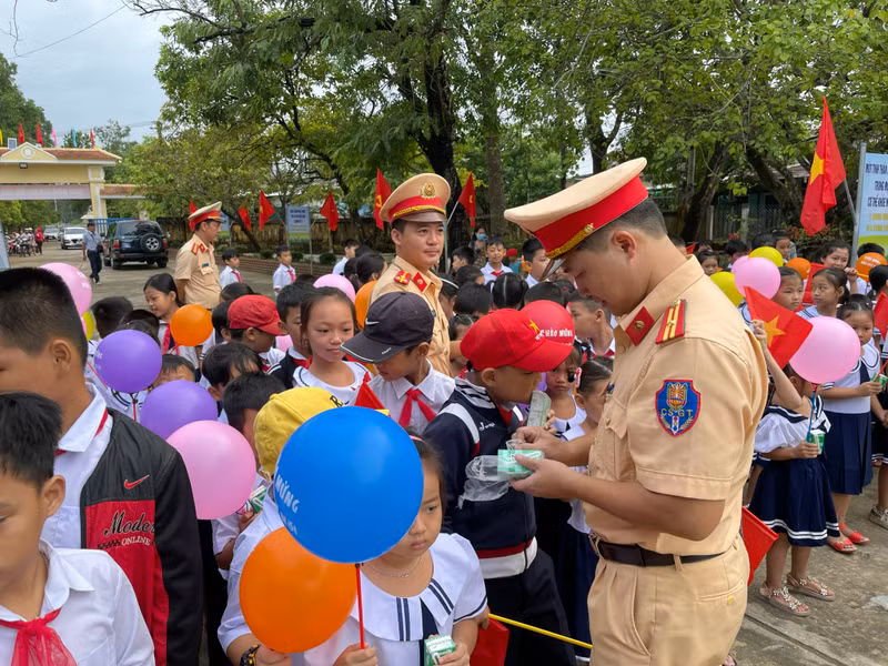 CSGT bóc các hộp sữa cho các học sinh nhỏ. CSGT Thừa Thiên - Huế phát sữa cho học sinh vùng sâu đi khai giảng sớm