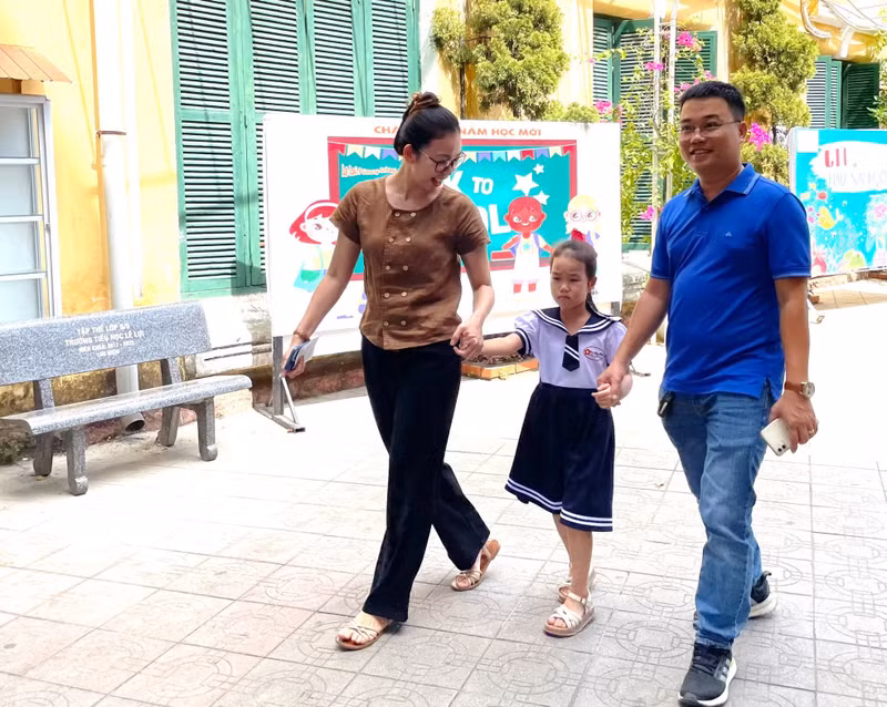 Bố mẹ đưa con gái đến tựu trường. Hình ảnh học sinh lớp 1 Thừa Thiên - Huế nô nức tựu trường sớm