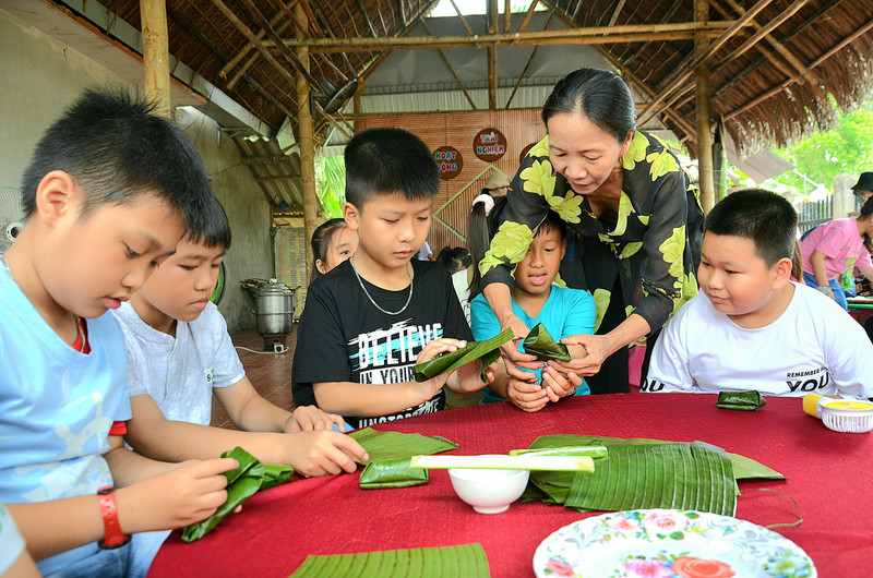 Học sinh thích thú trải nghiệm làm bánh truyền thống ở làng du lịch