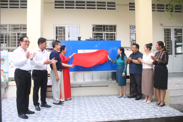 Đại biểu thực hiện nghi thức khánh thành, bàn giao hệ thống lọc nước.