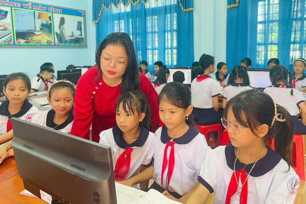 Cô giáo Trần Thị Huệ hướng dẫn học sinh thực hành môn Tin học. Ảnh: Đăng Đức