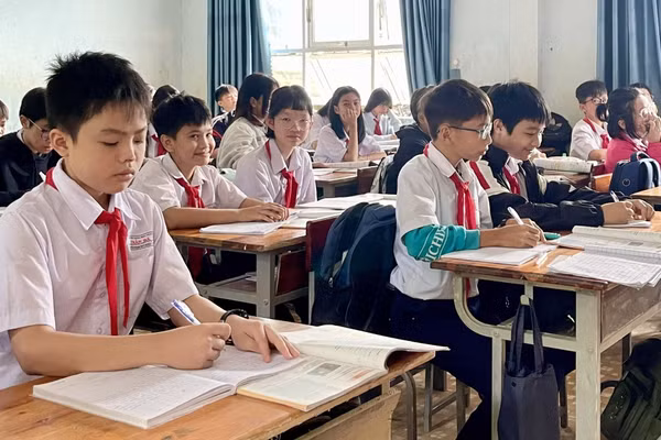 Một số học sinh bị hư hỏng sách giáo khoa trong đợt mưa lũ, phải dùng chung sách với bạn để chờ được hỗ trợ. Ảnh: Dung Nguyễn