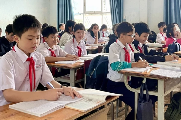 Một số học sinh bị hư hỏng sách giáo khoa trong đợt mưa lũ, phải dùng chung sách với bạn để chờ được hỗ trợ. Ảnh: Dung Nguyễn