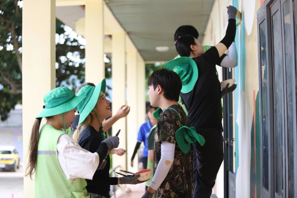 Sinh viên Hàn - Việt cùng các em nhỏ trang trí khuôn viên Trường Tiểu học Nguyễn Bá Ngọc. Ảnh: TT