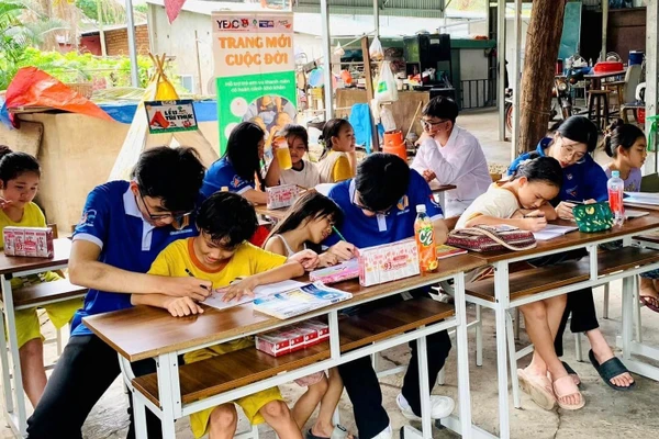 Các gia sư áo xanh dạy học cho trẻ tại “Lớp viết tiếp tương lai”. Ảnh: NVCC