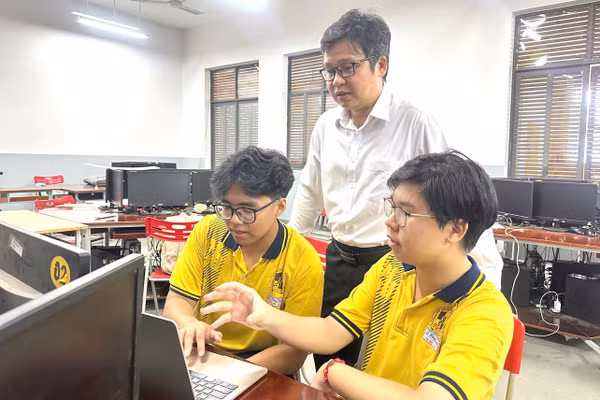 Tấn Đức (bên phải) và Nhật Bảo bàn luận về dự án cùng thầy hướng dẫn Đỗ Quốc Anh Triết. Ảnh: MA