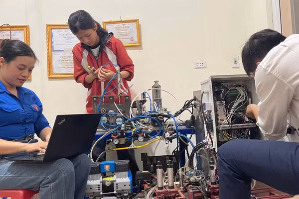 Cô Nguyễn Thùy Dương (ngoài cùng bên trái) hướng dẫn hai học sinh Nguyễn Tiến Mạnh và Dương Thị Duyên thực hiện đề tài “Máy tách, tuốt vỏ cây tế - nguyên liệu sản xuất sản phẩm tiêu dùng xanh”. Ảnh: NVCC