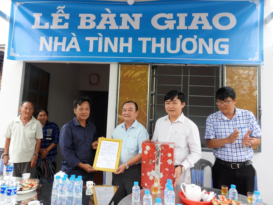 Ông Lê Văn Liêm - Chủ tịch UBND xã Phú Quới (huyện Long Hồ, tỉnh Vĩnh Long) trao quyết định bàn giao nhà cho gia đình ông Dương Thanh Nhã.