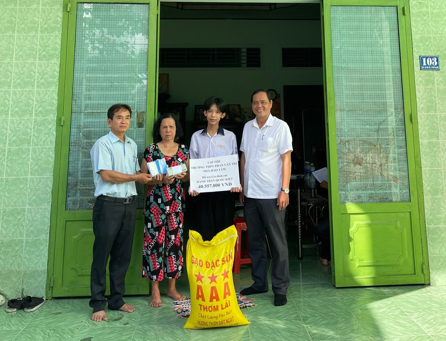 Đại diện Ban Giám hiệu Trường THPT Phan Văn Trị và Đảng ủy xã Mỹ Khánh trao cho gia đình em Danh Trần Quốc Kiệt số tiền 41.557.000 đồng.