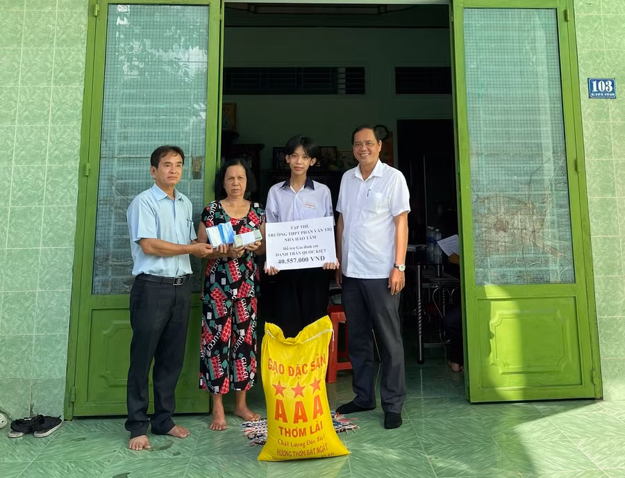 Đại diện Ban Giám hiệu Trường THPT Phan Văn Trị và Đảng ủy xã Mỹ Khánh trao cho gia đình em Danh Trần Quốc Kiệt số tiền 41.557.000 đồng.