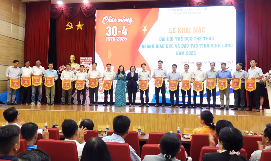 TS Đặng Thị Ngọc Lan - Phó Hiệu trưởng Trường ĐH Cửu Long và bà Trương Thanh Nhuận - Giám đốc Sở GD&ĐT tỉnh Vĩnh Long trao cờ lưu niệm cho các đội.