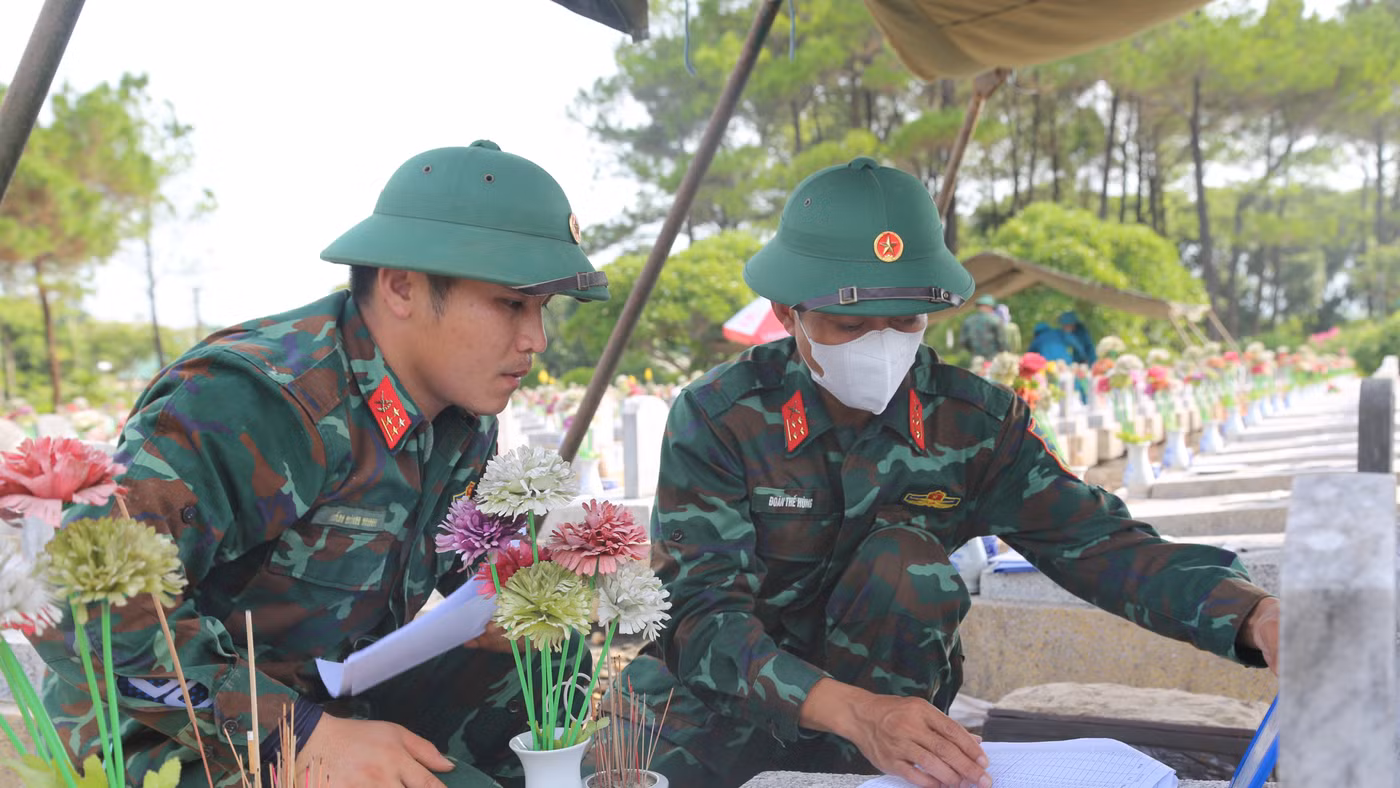 Lực lượng chức năng thực hiện quy trình lấy mẫu hài cốt liệt sĩ.