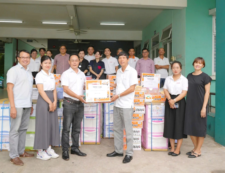 Nhà báo Nguyễn Anh Tú trao quà cho ông Đinh Hữu Tuyến – Giám đốc Trung tâm Bảo trợ trẻ em Tam Bình.