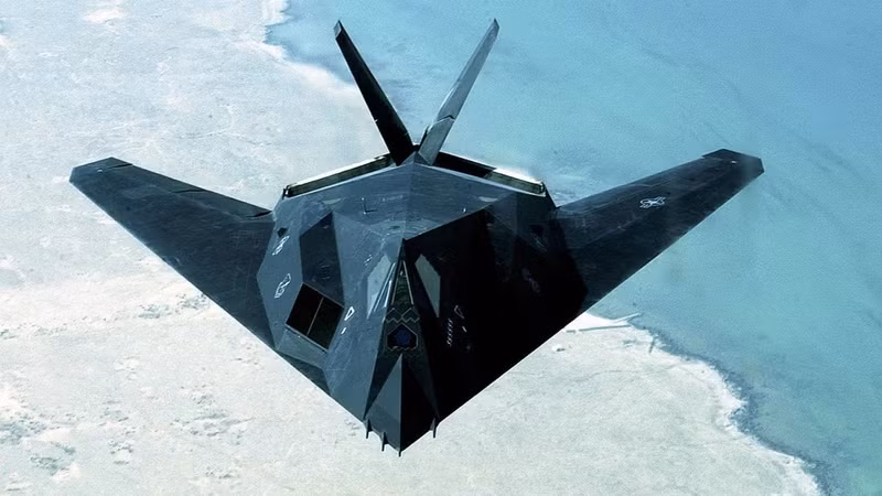 Lockheed F-117 Nighthawk. Ban đầu mang mật danh “Have Blue”, thử nghiệm từ 1977. Hình dáng góc cạnh kỳ lạ, bay đêm để tránh bị phát hiện. Dân địa phương thấy ánh sáng tam giác, Lầu Năm Góc phủ nhận tin đồn. bi-mat-nhung-chien-co-khien-the-gioi-rung-dong-thoi-chien-tranh-lanh-5.jpg
