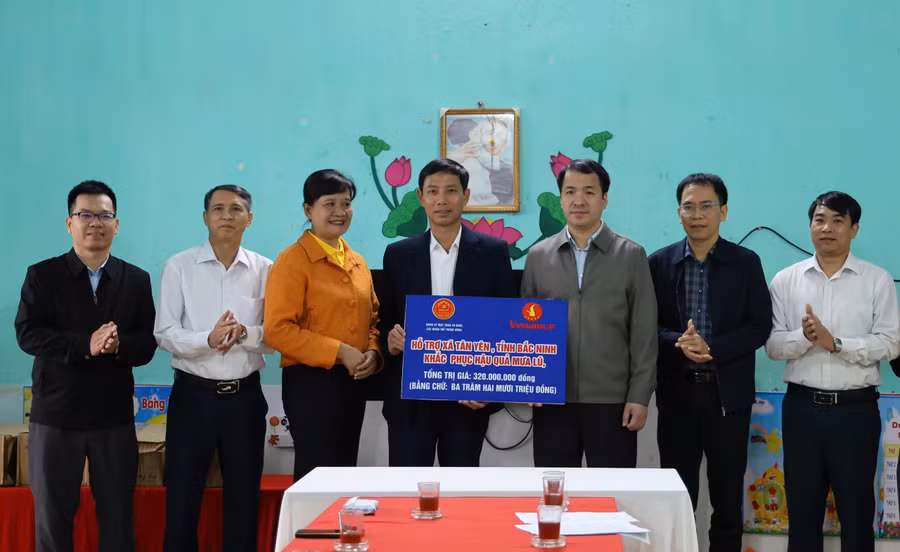 Ông Ngô Văn Cương cùng nhà tài trợ trao kinh phí hỗ trợ cho xã Tân Yên khắc phục hậu quả mưa lũ.