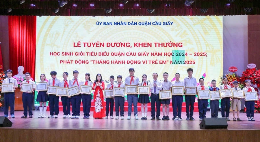 Bí thư Quận ủy Cầu Giấy Trần Thị Phương Hoa và ông Nguyễn Quang Tuấn - Phó Giám đốc Sở GD&ĐT Hà Nội khen thưởng các em học sinh.