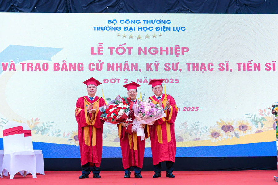 PGS.TS Vũ Đình Ngọ - Chủ tịch Hội đồng trường (bên trái ngoài cùng) và PGS.TS Đinh Văn Châu - Hiệu trưởng Trường Đại học Điện lực (bên phải ngoài cùng) tặng hoa chúc mừng TS. Dương Trung Kiên nhận công tác mới. dl-5.jpg