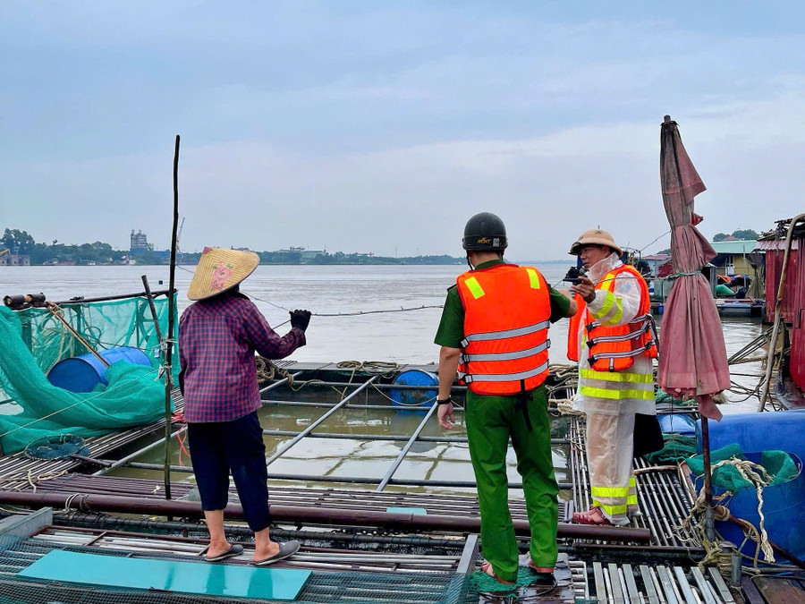 Đội Cảnh sát đường thủy số 2 cùng Công an xã Bát Tràng hướng dẫn người dân ứng phó bão. anh.jpg