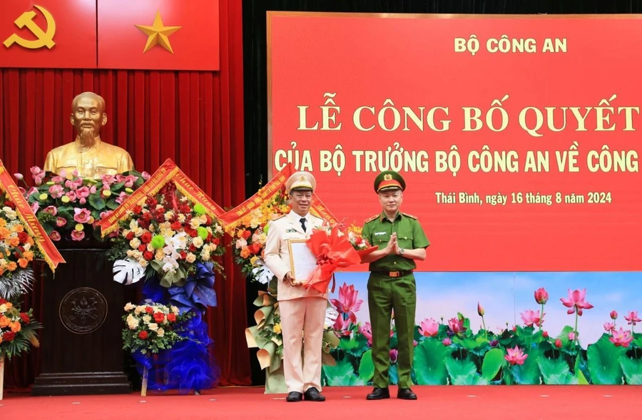 Thiếu tướng Nguyễn Ngọc Lâm, Thứ trưởng Bộ Công an, trao quyết định và tặng hoa chúc mừng Đại tá Trần Xuân Ánh.