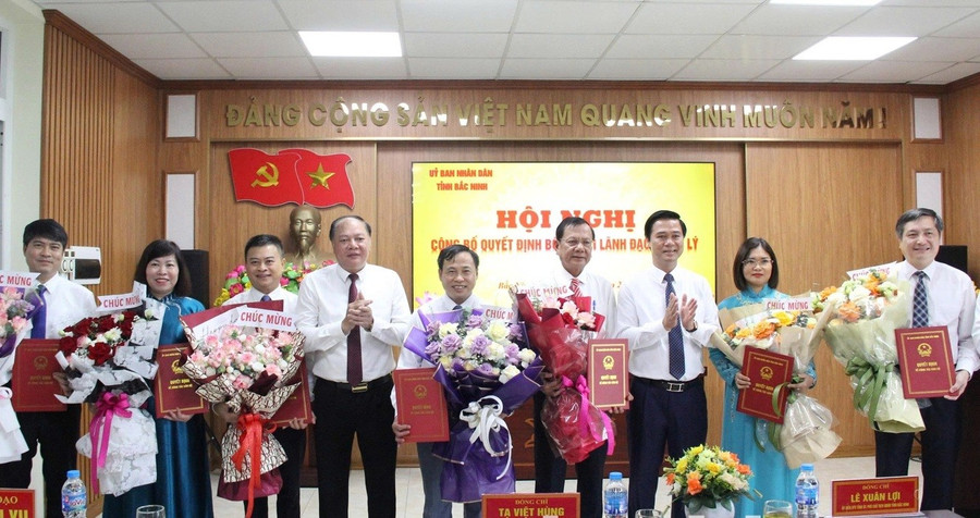 Phó Chủ tịch UBND tỉnh Bắc Ninh Lê Xuân Lợi (thứ 3 từ phải qua) và Giám đốc Sở GD&ĐT Tạ Việt Hùng trao Quyết định và tặng hoa chúc mừng các Phó Giám đốc Sở.