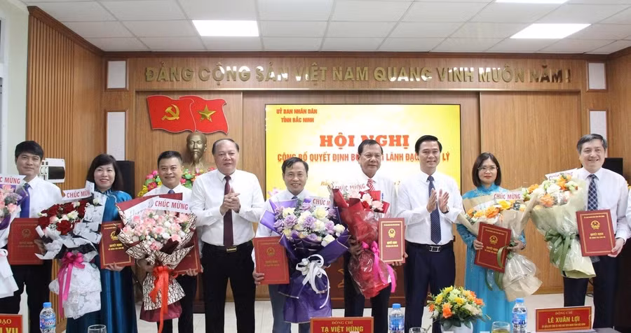 Phó Chủ tịch UBND tỉnh Bắc Ninh Lê Xuân Lợi (thứ 3 từ phải qua) và Giám đốc Sở GD&ĐT Tạ Việt Hùng trao Quyết định và tặng hoa chúc mừng các Phó Giám đốc Sở.