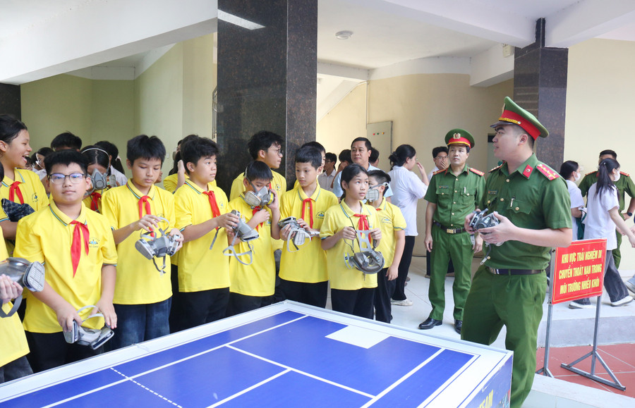 Cảnh sát hướng dẫn học sinh đeo mặt nạ phòng khói, khí độc khi gặp hỏa hoạn.