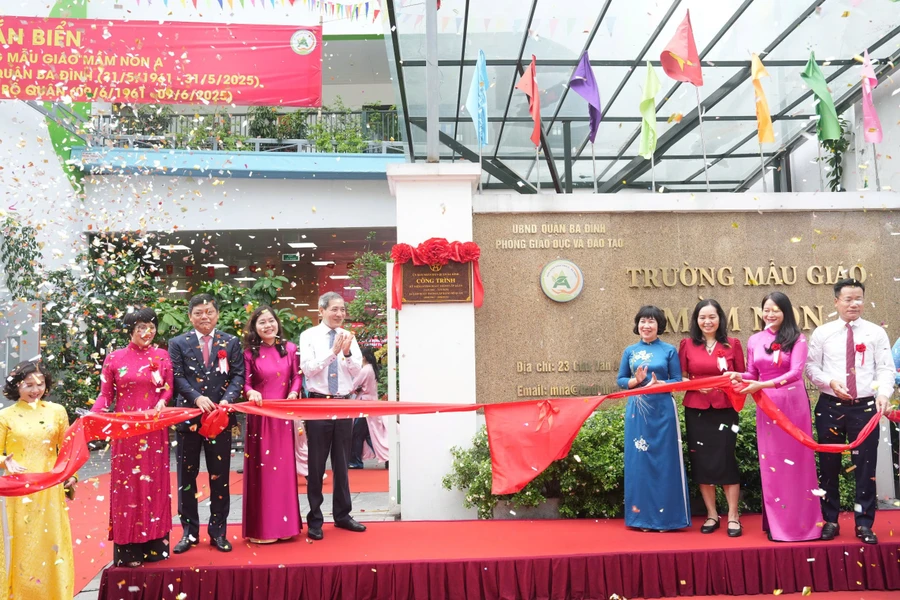 Các đại biểu thực hiện nghi thức gắn biển công trình chào mừng kỷ niệm 64 năm Ngày thành lập quận Ba Đình. 