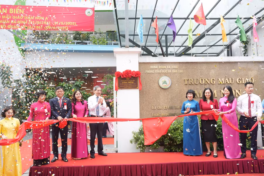 Các đại biểu thực hiện nghi thức gắn biển công trình chào mừng kỷ niệm 64 năm Ngày thành lập quận Ba Đình. 