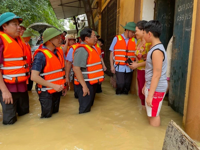 Thủ tướng Phạm Minh Chính trực tiếp vào khu dân cư thăm hỏi, động viên người dân tại xã Vân Hà, thị xã Việt Yên đang bị cô lập - Ảnh: VGP.