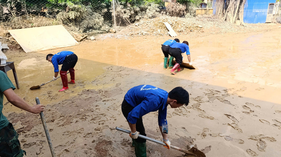 Sinh viên Trường Đại học Điện Lực dọn dẹp, hỗ trợ người dân khắc phục hậu quả sau mưa lũ.
