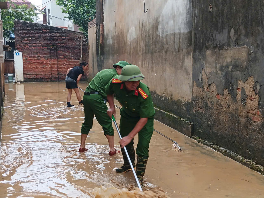 Công an hỗ trợ người dân vệ sinh sau mưa lũ. z7104853253160-ba992777d207408fe5f30ad4612012f9.jpg