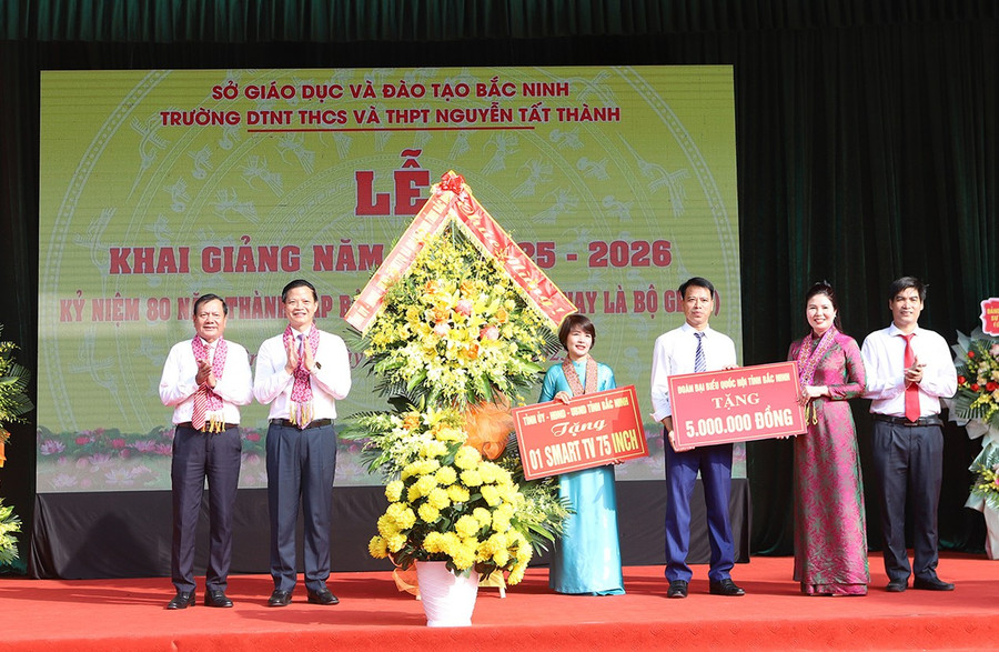Chủ tịch UBND tỉnh Bắc Ninh Vương Quốc Tuấn (thứ 2 từ trái qua) tặng hoa và quà cho Trường Dân tộc nội trú THCS và THPT Nguyễn Tất Thành. t2.jpg