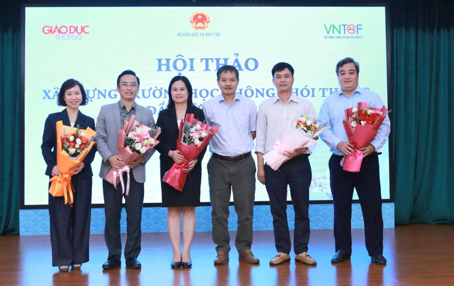 Nhà báo Nguyễn Đức Tuân tặng hoa các chuyên gia, đại biểu tham luận tại Hội thảo.