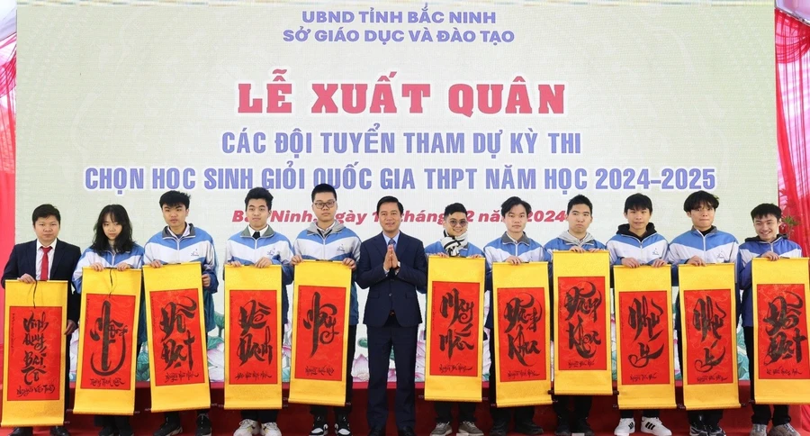 Phó Chủ tịch UBND tỉnh Bắc Ninh Lê Xuân Lợi trao tặng tranh chữ cho các em học sinh.