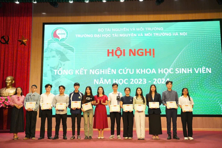 PGS.TS Lê Thị Trinh - Phó Hiệu trưởng Trường Đại học Tài nguyên và Môi trường Hà Nội (đứng giữa) cùng đại biểu trao khen thưởng cho sinh viên.