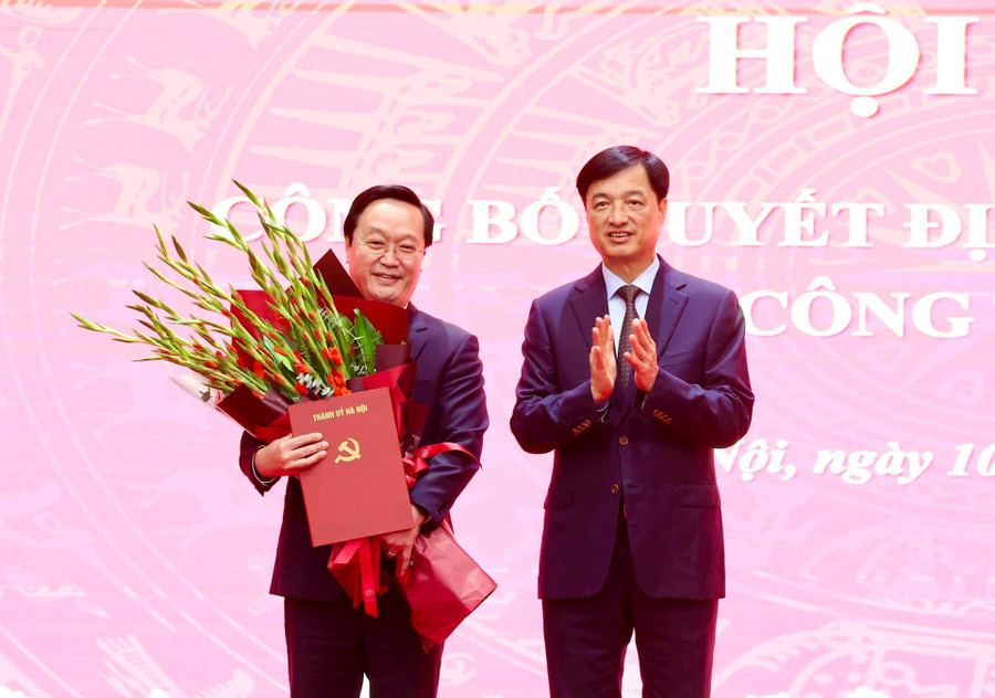 Bí thư Thành ủy Hà Nội Nguyễn Duy Ngọc trao quyết định và tặng hoa chúc mừng ông Nguyễn Đức Trung. Ảnh: VT.