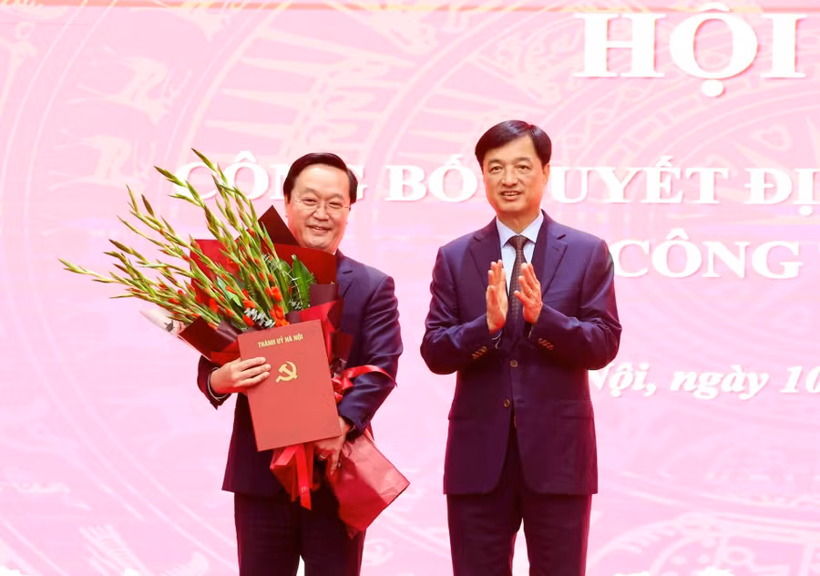 Bí thư Thành ủy Hà Nội Nguyễn Duy Ngọc trao quyết định và tặng hoa chúc mừng ông Nguyễn Đức Trung. Ảnh: VT.