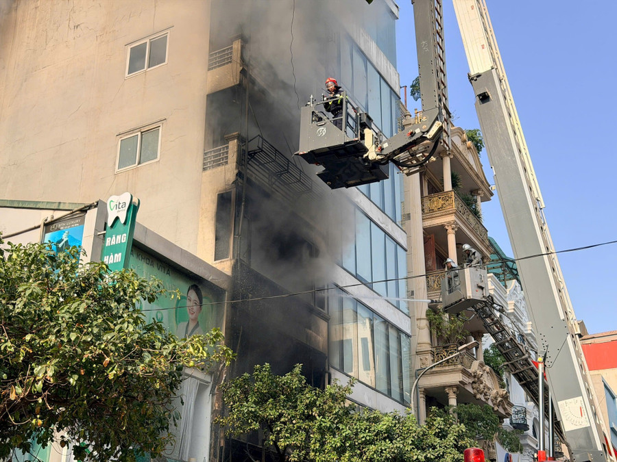 Cảnh sát tiếp cận tầng cao căn nhà bằng xe thang.