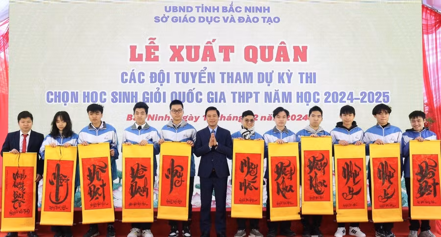 Phó Chủ tịch UBND tỉnh Bắc Ninh Lê Xuân Lợi trao tặng tranh chữ cho các em học sinh.