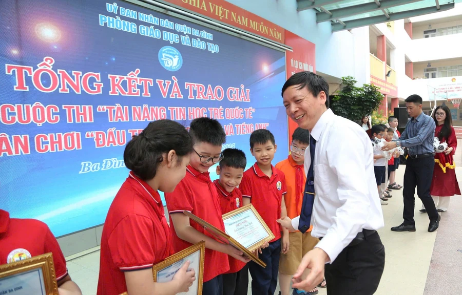 Ông Nguyễn Như Tùng trao giải, chúc mừng các em học sinh.