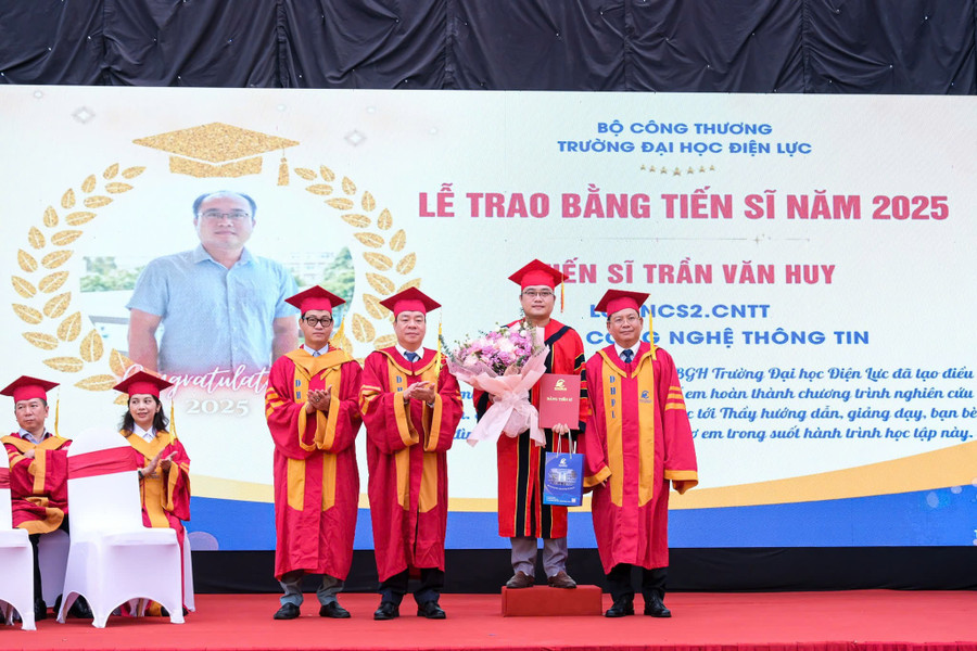 PGS.TS Vũ Đình Ngọ - Chủ tịch Hội đồng trường (thứ 2 từ trái sang phải) và PGS.TS Đinh Văn Châu - Hiệu trưởng Trường Đại học Điện lực (bên phải ngoài cùng) trao bằng tốt nghiệp và chúc mừng tân tiến sĩ. dl-12.jpg
