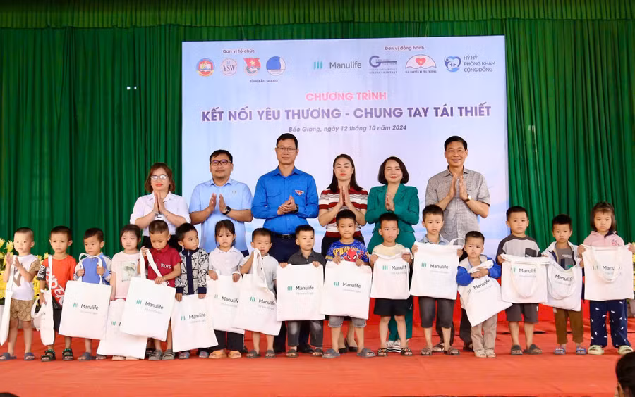 Đại biểu trao quà cho học sinh xã Tân Lập.