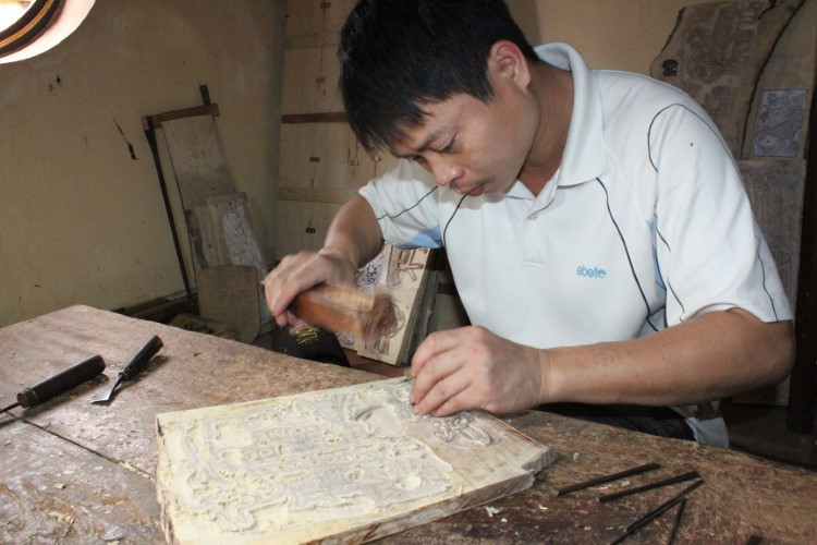 Thợ khắc mẫu trên bản gỗ.