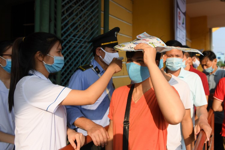 Các CĐV thực hiện các bước kiểm tra y tế trước khi vào sân Thiên Trường theo dõi trận đấu.