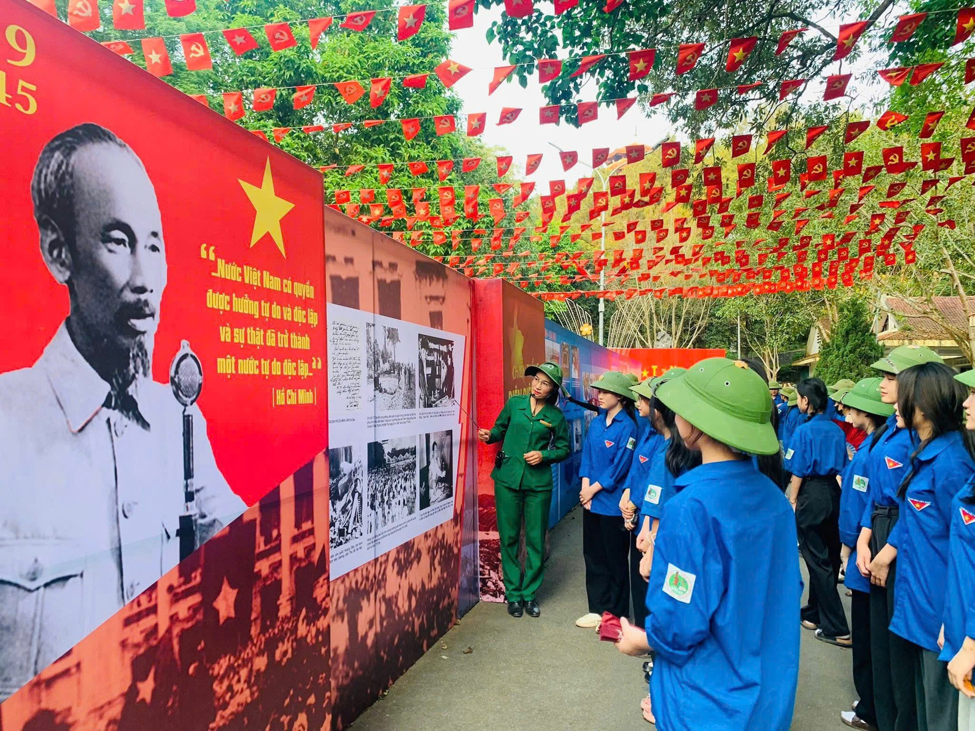Các bạn trẻ đang chăm chú lắng nghe hướng dẫn viên thuyết trình về Khu di tích Ngã ba Đồng Lộc.