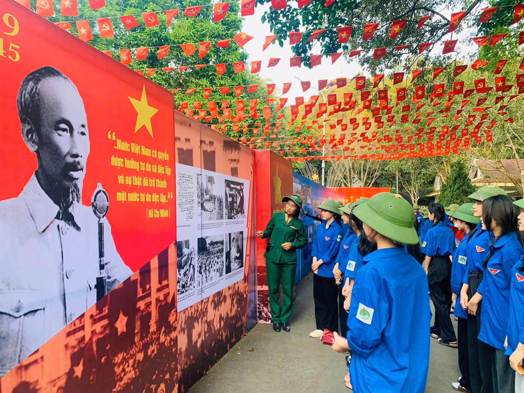 Các bạn trẻ đang chăm chú lắng nghe hướng dẫn viên thuyết trình về Khu di tích Ngã ba Đồng Lộc.