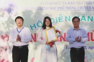Phó Giám đốc Sở GD&ĐT tỉnh Vĩnh Long Võ Văn Bé Hai đại diện lãnh đạo tỉnh trao thư chúc mừng của Chủ tịch UBND tỉnh Trần Trí Quang cho em Trịnh Phương Thảo.
