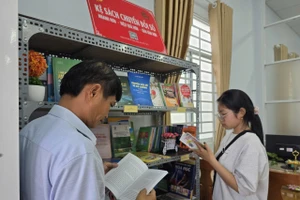 Người dân đọc sách trong thời gian chờ tại Trung tâm Phục vụ hành chính công xã Thạnh Hòa (TP Cần Thơ).